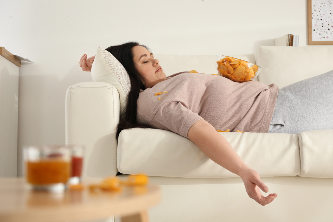 Plus Size Woman Sleeping on Sofa with Chips